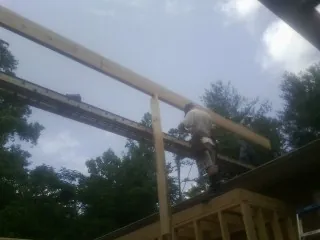 Carpenter setting a ridge beam over a new addition frame — Ice Dam Removal by Roofing Brothers in Dundas