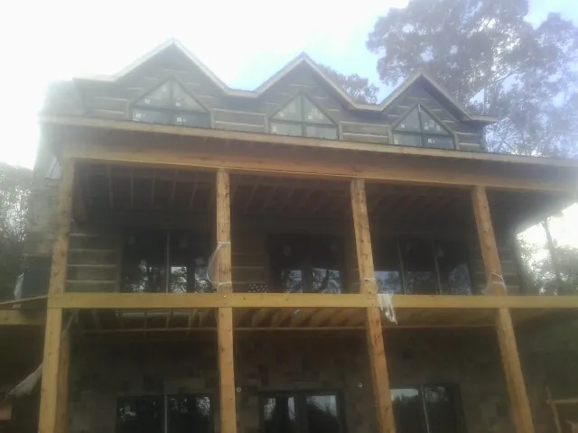 Dormers and porch framing on a large log home under construction — Roof Coating work by our crew in Dundas